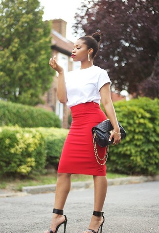 Белая футболка с круглым вырезом и красная юбка-карандаш — необходимые вещи в арсенале стильной современной женщины. Очень выигрышно здесь будут смотреться черные кожаные босоножки на каблуке.