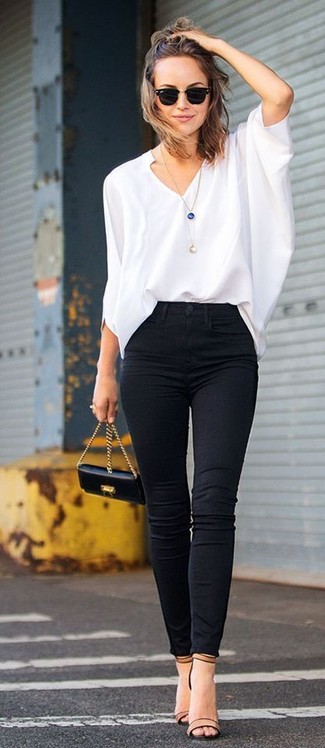 Стильное сочетание белой блузки с длинным рукавом и черных джинсов скинни поможет выразить твою индивидуальность и выделиться из толпы. Чтобы немного разнообразить образ и сделать его элегантнее, можно надеть светло-коричневые кожаные босоножки на каблуке.