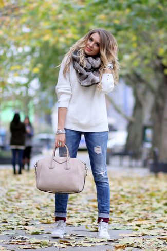 Белый вязаный свитер и синие рваные джинсы можно надеть как на учебу, так на прогулку с друзьями. Любительницы экспериментировать могут завершить образ белыми высокими кедами.