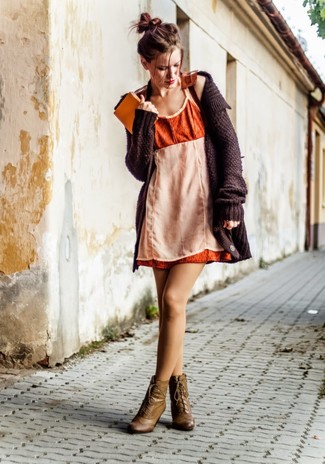 Стильное сочетание темно-коричневого вязаного кардигана и оранжевого платья-майки поможет выразить твою индивидуальность и выделиться из толпы. Оливковые кожаные ботильоны на шнуровке добавят образу эффектности.
