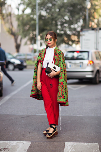 Зеленое пальто с цветочным принтом и красные классические брюки — отличный вариант повседневного офисного образа. Черные замшевые босоножки на танкетке помогут сделать образ менее официальным.