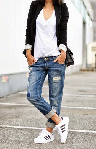 Черный пиджак и синие рваные джинсы-бойфренды — идеальный вариант непринужденного повседневного лука. Любительницы экспериментировать могут завершить образ белыми кроссовками.