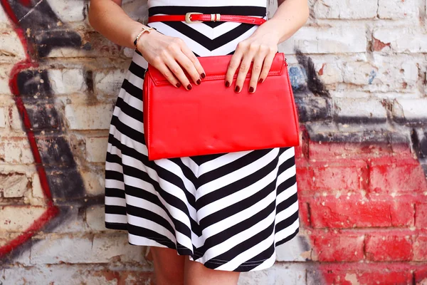 Модная женщина с красной сумочкой в руках крупным планом — стоковое фото